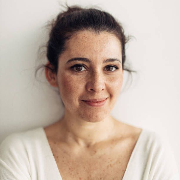 Portrait of a beautiful, freckled smiling woman in her 30s